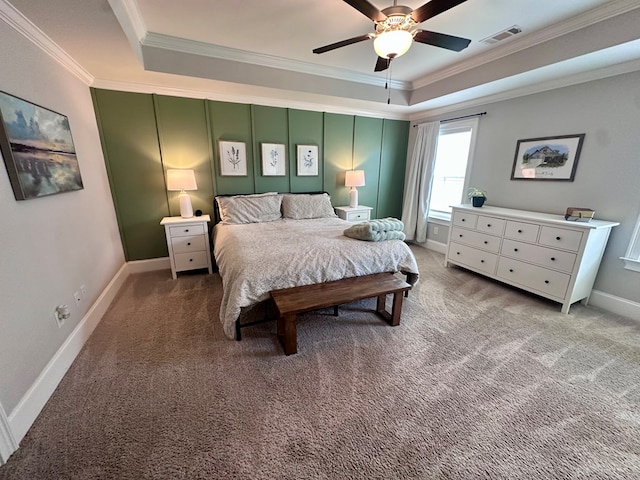 carpeted bedroom featuring crown molding, baseboards, visible vents, and a raised ceiling