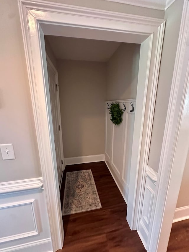 corridor with dark wood-type flooring and baseboards