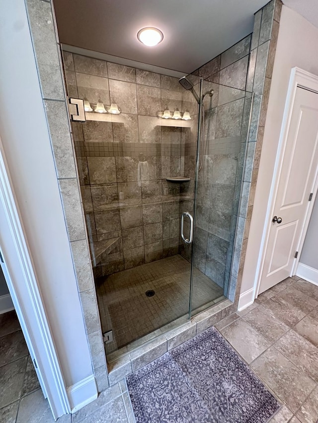 bathroom with baseboards and a stall shower