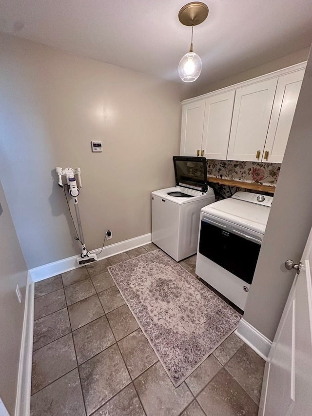 laundry area featuring baseboards, cabinet space, and washer and dryer