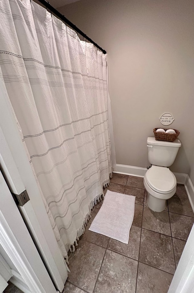 full bathroom featuring toilet and baseboards