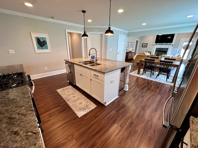 kitchen with a kitchen bar, dark wood finished floors, a sink, baseboards, and stainless steel appliances