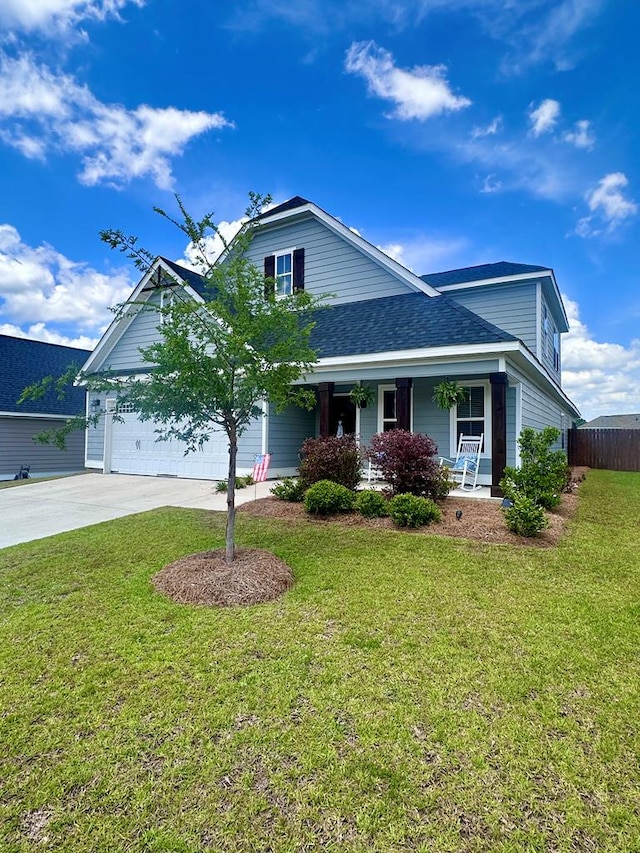 traditional-style house with covered porch, fence, driveway, and a front lawn