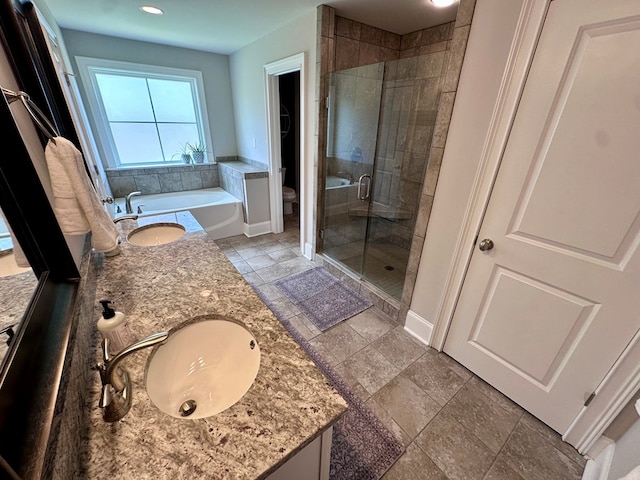 full bath with double vanity, a shower stall, a sink, baseboards, and toilet