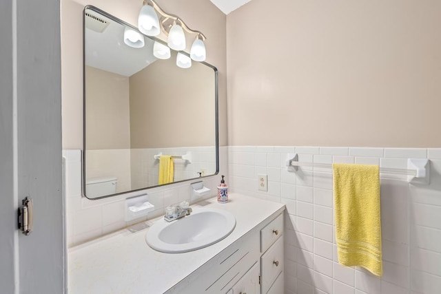 bathroom with wainscoting, tile walls, and vanity