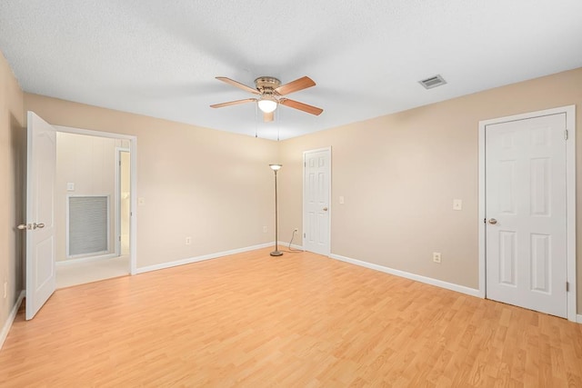 unfurnished room with baseboards, visible vents, and light wood finished floors