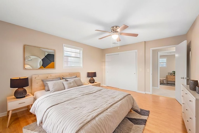 bedroom featuring light wood-type flooring, a closet, baseboards, and a ceiling fan