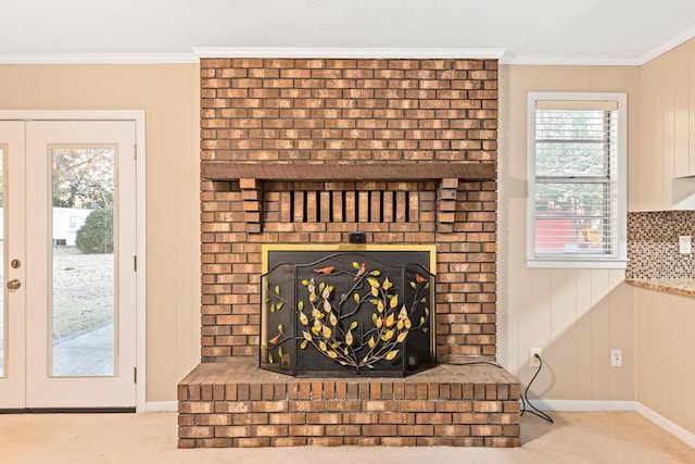 details featuring crown molding, a fireplace, carpet flooring, and french doors