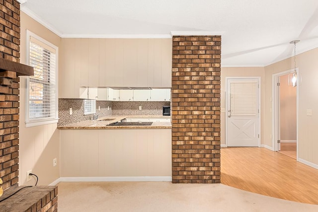 kitchen with pendant lighting, decorative backsplash, white cabinets, a sink, and light stone countertops