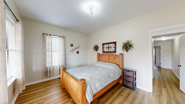 bedroom featuring light hardwood / wood-style flooring and a textured ceiling