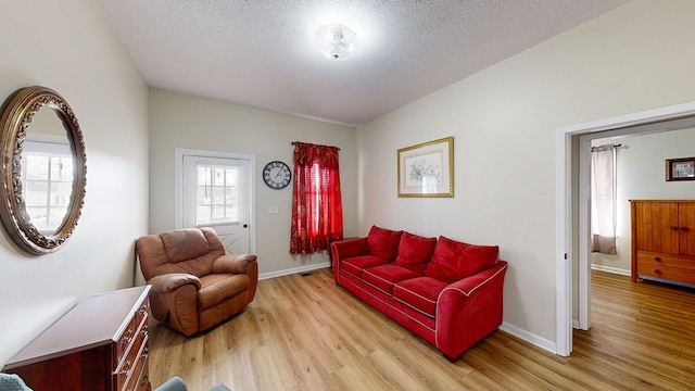 living room with light hardwood / wood-style floors and a textured ceiling