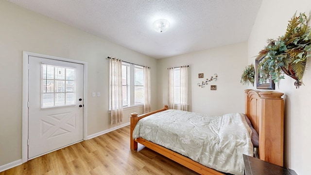 bedroom with light hardwood / wood-style flooring and a textured ceiling