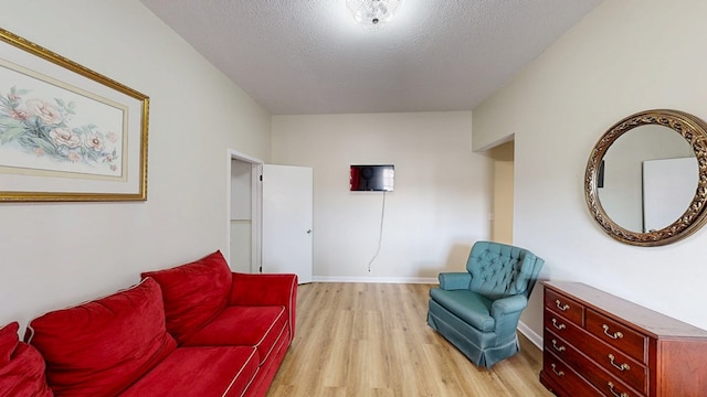 living area with a textured ceiling and light wood-type flooring