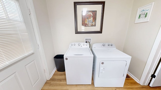 clothes washing area featuring washer and clothes dryer and light hardwood / wood-style flooring