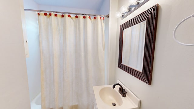 bathroom with shower / bathtub combination with curtain and sink