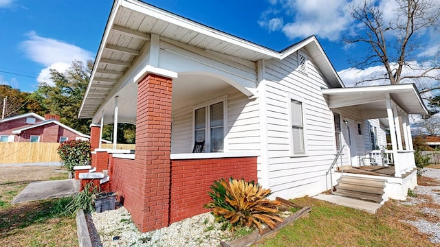 view of side of home featuring covered porch