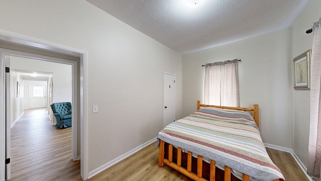 bedroom featuring a textured ceiling and light wood-type flooring