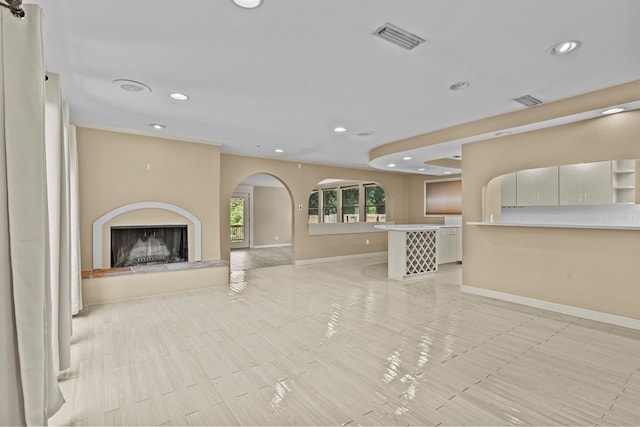 122 Greenview Cir, Dothan, AL 36301 - unfurnished living room featuring recessed lighting, arched walkways, baseboards, a fireplace with raised hearth, and light tile patterned flooring
