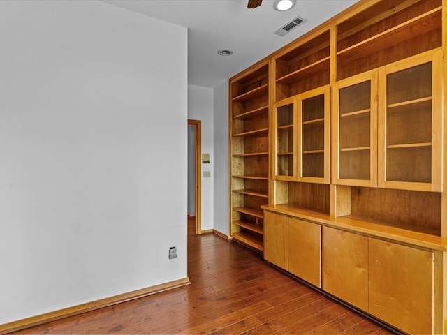 empty room with dark wood-type flooring and ceiling fan