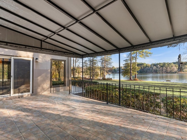 unfurnished sunroom featuring a water view and lofted ceiling