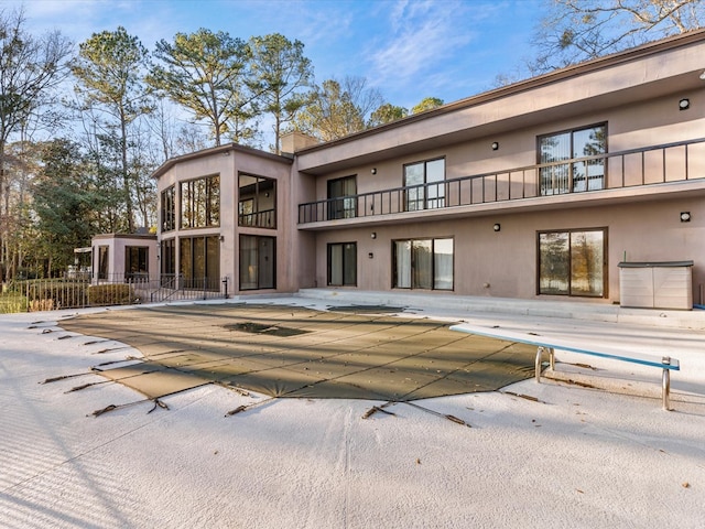 back of property with a covered pool and a patio area