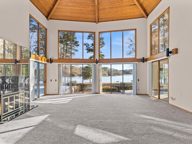 unfurnished living room with carpet flooring, wood ceiling, high vaulted ceiling, and a water view