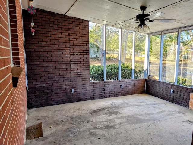 unfurnished sunroom featuring ceiling fan and plenty of natural light