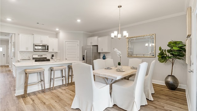 dining space featuring light wood-type flooring, baseboards, ornamental molding, and a chandelier