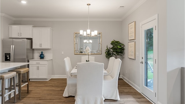 dining area with crown molding, a notable chandelier, dark wood finished floors, and baseboards