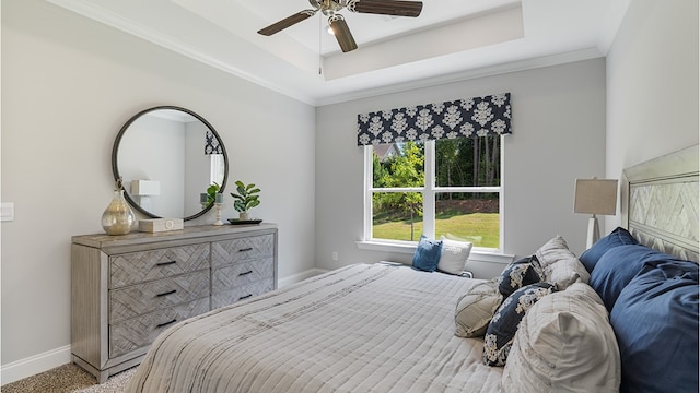 bedroom featuring carpet floors, a tray ceiling, crown molding, and baseboards