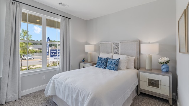 carpeted bedroom featuring baseboards and visible vents