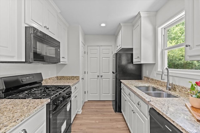 1182 N N Park Ave, Dothan, AL 36303 - kitchen with black appliances, white cabinets, light wood-type flooring, healthy amount of natural light, and recessed lighting