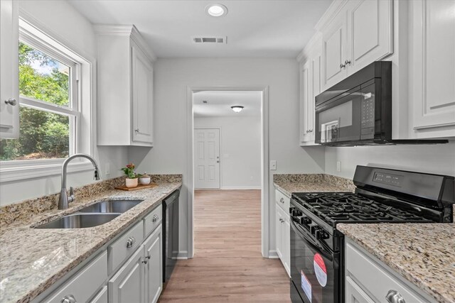 1182 N N Park Ave, Dothan, AL 36303 - kitchen with black appliances, light wood-style floors, white cabinets, recessed lighting, and light stone counters