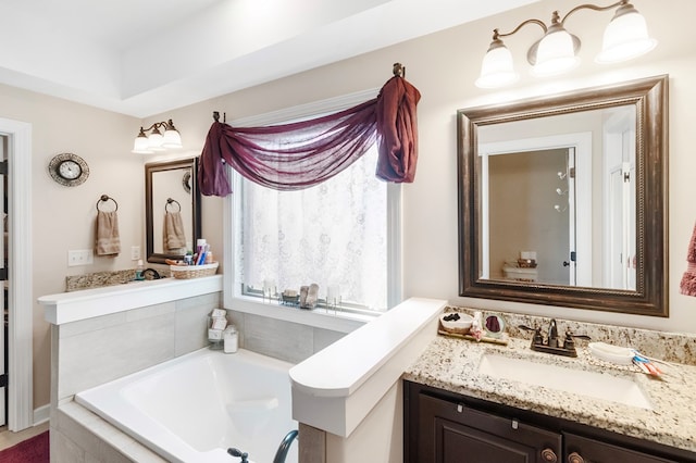 bathroom featuring tiled tub and vanity