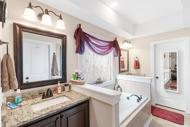 bathroom with tile patterned floors, vanity, and tiled bath