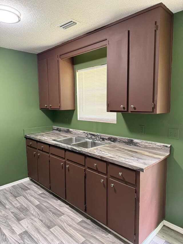 1208 E Newton St, Dothan, AL 36303 - kitchen with a sink, a textured ceiling, baseboards, and light floors