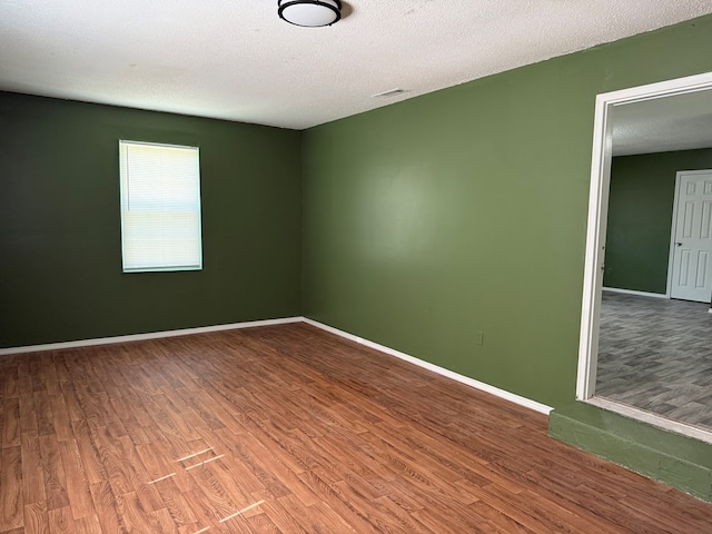 1208 E Newton St, Dothan, AL 36303 - spare room featuring wood finished floors, baseboards, and a textured ceiling