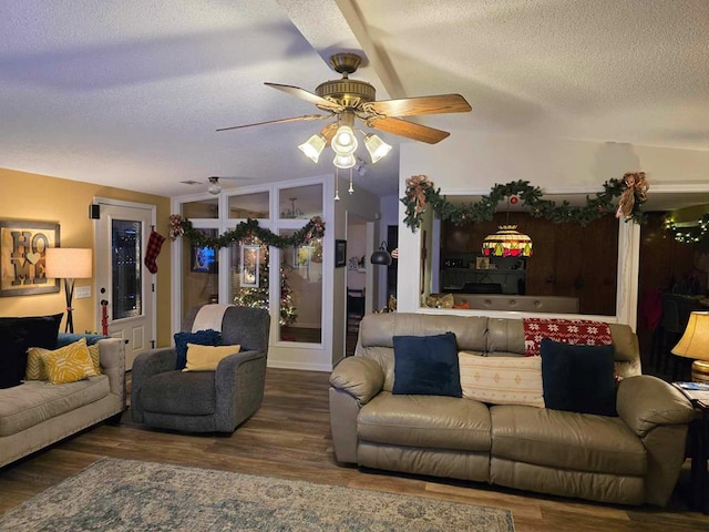 living room featuring hardwood / wood-style floors, ceiling fan, and a textured ceiling