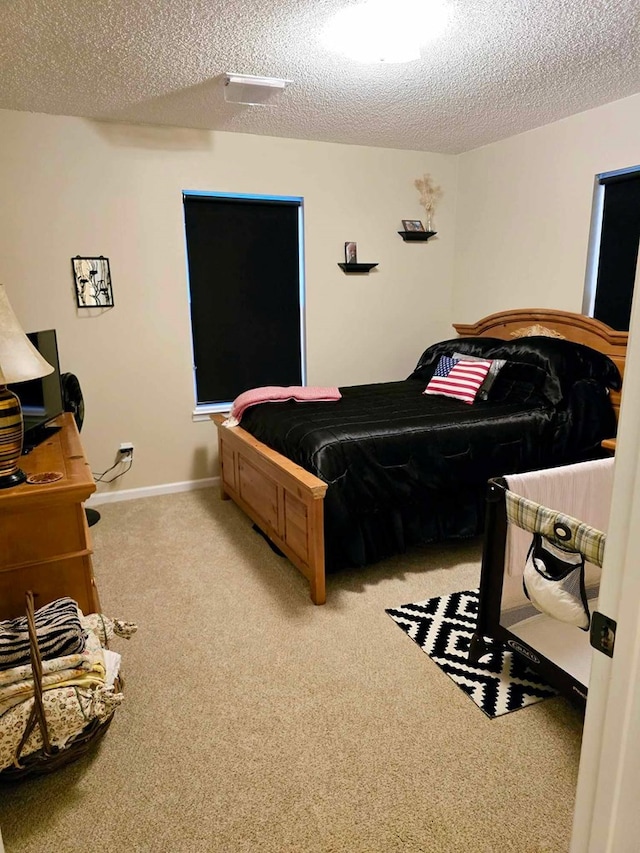 bedroom featuring light carpet and a textured ceiling