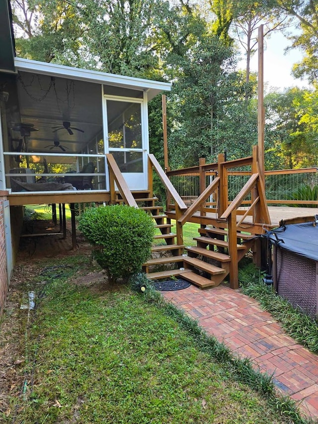 view of yard with ceiling fan, a wooden deck, and a sunroom