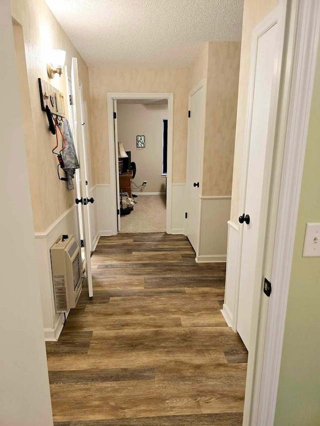 corridor with a textured ceiling and dark hardwood / wood-style floors