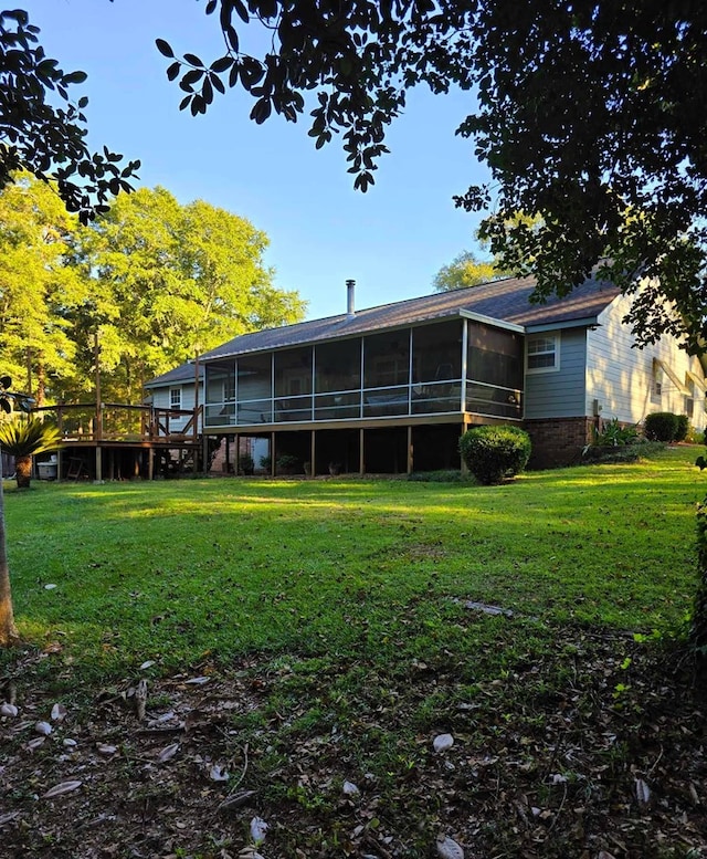 back of house featuring a lawn and a sunroom