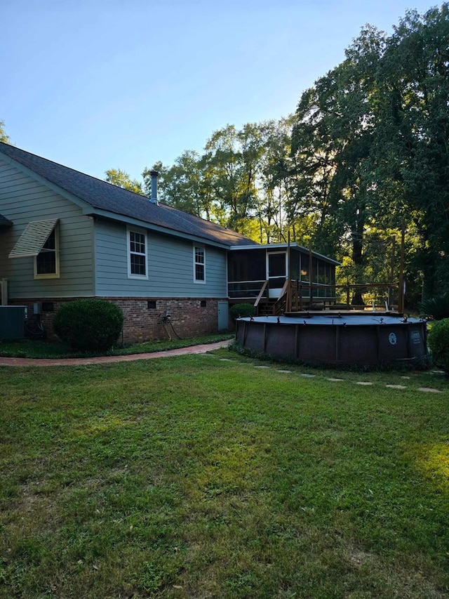 view of yard with a sunroom and central AC unit