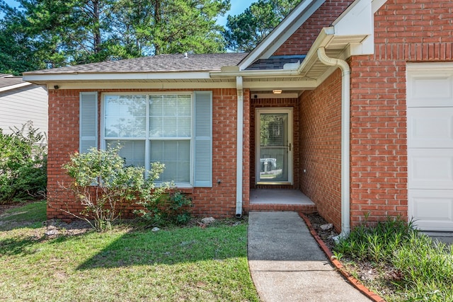 706 W Roxbury Rd, Dothan, AL 36305 - doorway to property featuring brick siding, a yard, and a garage