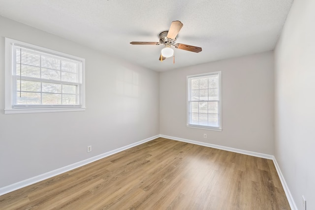 unfurnished room with a textured ceiling, light wood-type flooring, and ceiling fan