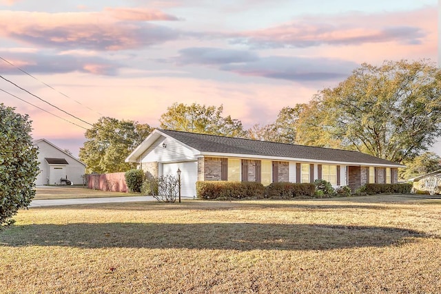 ranch-style home featuring brick siding, a lawn, an attached garage, and fence