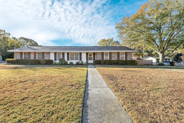 ranch-style home featuring a garage and a lawn