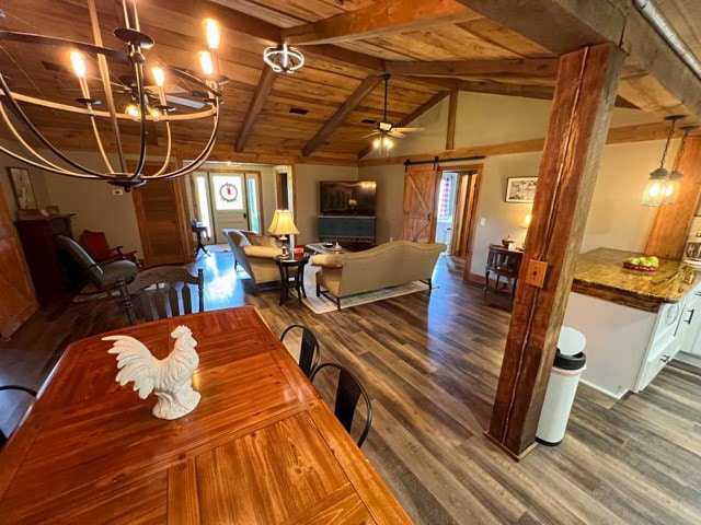 dining space with ceiling fan with notable chandelier, vaulted ceiling with beams, dark hardwood / wood-style floors, a barn door, and wood ceiling