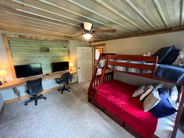 bedroom with ceiling fan, carpet, and built in desk