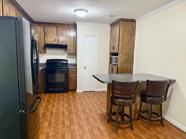 171 Merrydell Dr, Ozark, AL 36360 - kitchen featuring freestanding refrigerator, black electric range, under cabinet range hood, stainless steel microwave, and ornamental molding
